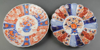 A late 19th Century Imari scalloped dish decorated with panels of birds and flowers enclosing a central panel of a vase of flowers 11", a similar later ditto 11" 