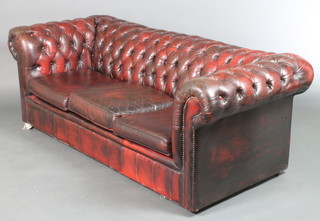A 3 seat Chesterfield upholstered in buttoned back red leather 26"h x 77"w x 34"d 