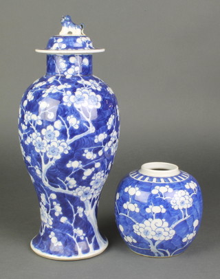 An early 20th Century blue and white prunus waisted oviform vase and cover with lion finial 15" together with a ditto ginger jar 5" 