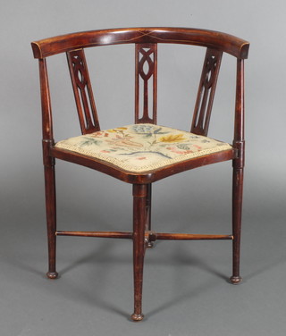 An Edwardian inlaid mahogany corner chair with pierced slat back and Berlin wool work seat, on turned supports with X framed stretcher 