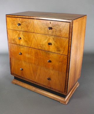 An Art Deco figured walnut chest with quarter veneered and crossbanded top fitted 2 short and 3 long drawers, raised on a shaped and ebonised base 41"h x 36"w x 19 1/2"d 