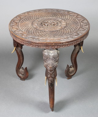 An Indian 19th Century circular carved hardwood occasional table, the top decorated a Goddess and elephant attendants, raised on 3 elephant supports 24"h x 25" diam. 
