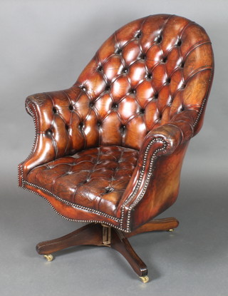 A tub back revolving office chair upholstered in brown buttoned back leather 