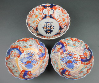 A pair of late 19th Century Imari scalloped bowls, the centre panel with a vase of flowers surrounded by panels of flowers and trees 9", a deeper ditto 10" 