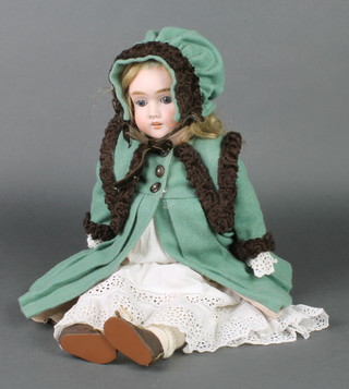 A 19th Century German porcelain headed doll with sleep eyes, open mouth with 2 teeth, the head incised MAH Handwerck Germany, clothed in a white gown and with green bonnet and coat