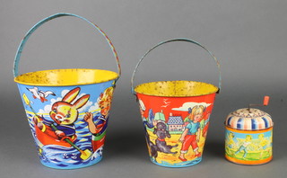 2 Chad Valley pressed metal sandcastle buckets 6" and 5" together with a cylindrical pressed metal musical box decorated a footballing scene 3" 