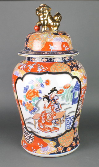 A 20th Century Imari baluster vase and cover decorated with panels of figures in garden landscapes on a ground of flowers, the lid with gilt shi shi  finial 4" 
