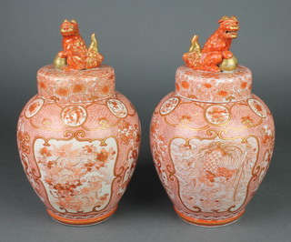 A pair of late 19th Century Kutani baluster vases with interior lids and covers, the body decorated with figures in pavilions, terraces and panels of exotic birds in a field of flowers, the lids with Shi Shi finials, 11"  