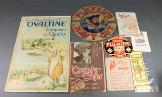 A cardboard Ovaltine sign "Too Many Reasons Why Ovaltine is Superior in Quality" 20" x 13 1/2", an oval sign for Harris's Flu-Nips 6" x 7" together with a 1930's cardboard Comfy Cap shop display sign 12" x 8" (slightly dogeared) and a Player's Navy Cut box lid (cut to the life ring and with split to the back) 12"