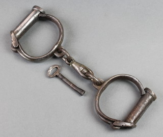 A pair of iron handcuffs marked Hard 21 together with an associated key 