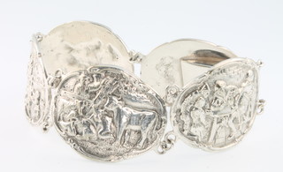 A Continental repousse silver 5 plaque bracelet decorated with revelling scenes and animals 