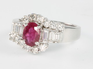 A 14ct white gold ruby and diamond ring the oval centre stone 1.26ct surrounded by brilliant and baguette cut diamonds 0.9ct size 0