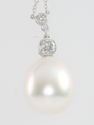 An 18ct white gold necklace hung a 3 stone diamond and large cultured pearl pendant 
