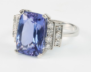 An 18ct white gold tanzanite and diamond Art Deco style ring, the cushion cut tanzanite approx. 7.5ct flanked by 2 tiers of brilliant cut diamonds approx. 0.5ct, size R