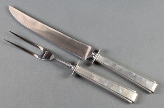 A carving fork and knife with sterling silver handles 