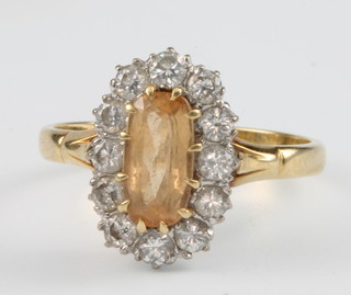 An 18ct yellow gold oval citrine and diamond cluster ring, the centre oval citrine surrounded by 12 brilliant cut diamonds, size P 1/2