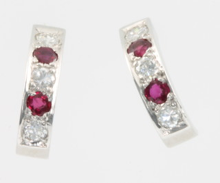 A pair of 18ct white gold ruby and diamond half hoop earrings each with 2 rubies and 3 diamonds 