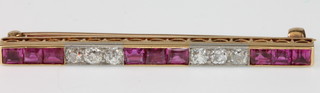 A Victorian yellow gold ruby and diamond bar brooch comprising 6 brilliant cut diamonds and 9 princess cut rubies 