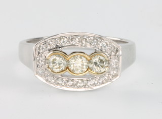 A 14ct white and yellow gold art deco style diamond ring with 3 centre stones enclosed by 17 diamonds size 0 1/2