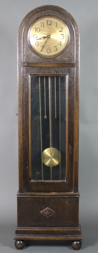 A 1930's longcase clock, striking on gong, with 11" gilt dial and Arabic numerals, contained in an arched oak case and raised on bun feet 77"h 