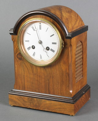 Woppenheim, a French 19th Century 8 day striking mantel clock, the 4" enamelled dial with Roman numerals (chip to base) contained in an arch shaped walnut case with pierced grilled panels to the sides 