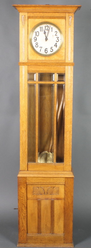 An Art Nouvea longcase clock,  striking on gong, with 9 1/2" silvered dial and Arabic numerals contained in a carved oak case, the base fitted a cupboard enclosed by a panelled door 74" 