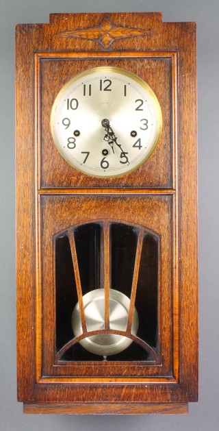 Enfield, a 1930's chiming wall clock with 7" silvered dial and Arabic numerals contained in an oak case enclosed by a sunburst shaped door 