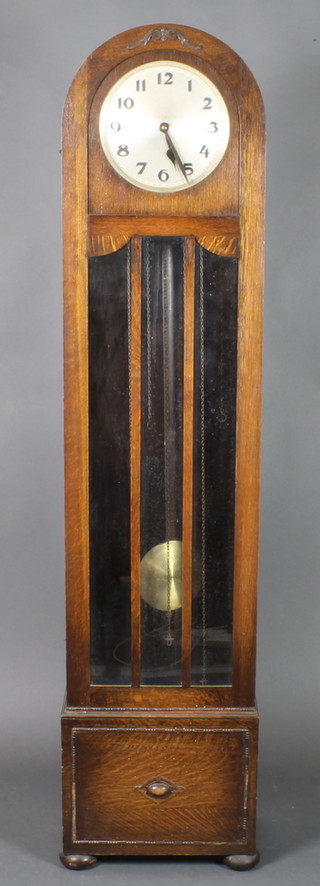 A 1930's Art Deco longcase clock,  striking on gong, with 10" circular silvered dial with Arabic numerals, contained in an oak arch shaped case raised on bun feet 73"h 