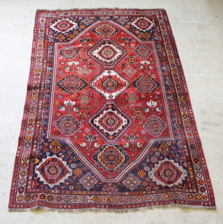 A red ground Persian carpet with central medallion within multi-row borders 115" x 75 1/2" 