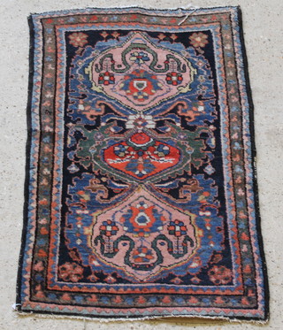 A blue and pink ground Persian rug with medallions to the centre within multi-row borders 45" x 28" 
