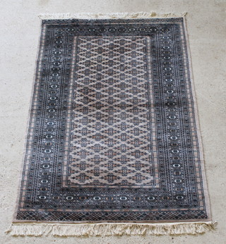 A sand ground Bokhara rug with all-over geometric design within multi-row borders 75" x 49 1/2" 