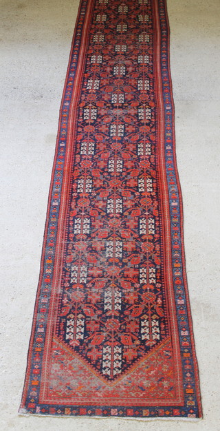 A Persian Malayer red and blue ground runner with all-over geometric designs 201" x 38" 