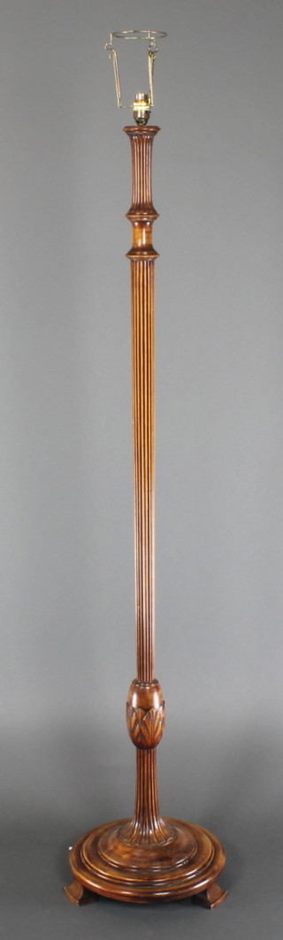 A turned and reeded mahogany standard lamp, raised on a circular base 