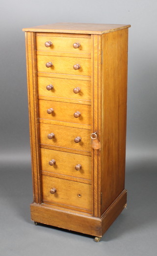 A Victorian oak Wellington chest of 7 long drawers with tore handles, raised on a platform base 44 1/2"h x 17"w x 16"d 