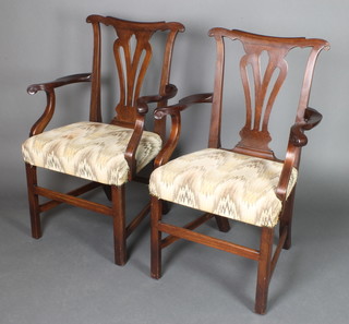 A pair of Georgian mahogany slat back carver chairs with pierced vase shaped slat backs, upholstered over-stuffed seats, raised on square tapering supports with H framed stretcher