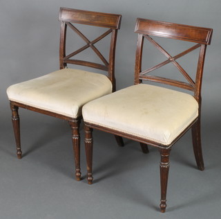 A pair of 19th Century mahogany bar back dining chairs with X framed mid rails and over stuffed seats, raised on turned and reeded supports