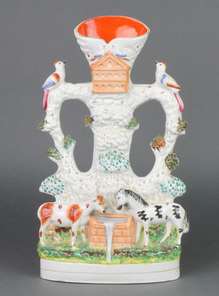 A Victorian Staffordshire spill vase in the form of a cow and horse drinking from a trough beneath a bird house flanked by birds 13" 