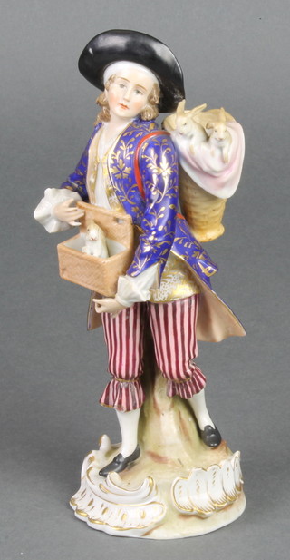 A 19th Century German porcelain figure of a gentleman with rabbits in a basket on his shoulder and a rabbit appearing from a basket at his waist 8"  