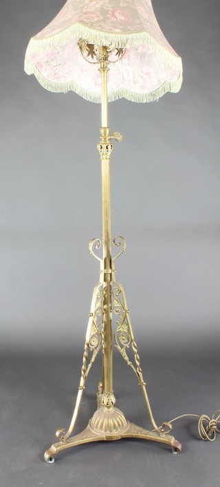 A Victorian reeded brass adjustable standard oil lamp (converted to electricity), raised on a triform base  
