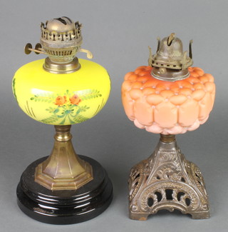 A Victorian opaque orange glass oil lamp reservoir raised on a pierced iron foot together with a ditto yellow glass oil lamp 