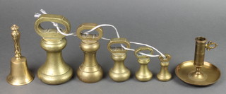 A set of 5 brass bell weights 5lb, 4lb, 2lb, 1lb and 8ozs together with a brass hand bell 6" and a brass chamber stick 4" 
