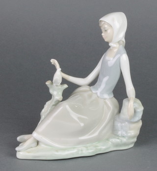 A Lladro figure of a seated girl admiring with dove 7" 
