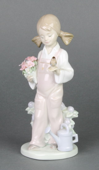 A Lladro figure of a girl holding a bouquet of flowers a bird on her other hand 5217, boxed 7" 