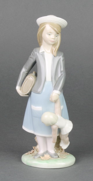 A Lladro figure of a school girl holding a doll 8"