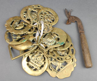 An early steel tin opener together with 17 various horse brasses