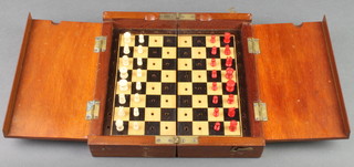 A 19th Century turned ivory and mahogany travelling chess set contained in a folding case 