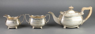 A silver 3 piece tea set with gadrooned decoration and fruitwood handles on ball feet, Sheffield 1925, 1212 grams gross