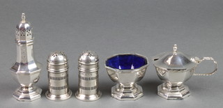 A silver octagonal 3 piece condiment with blue glass liners, Birmingham 1987, 140 grams together with a pair of pierced peppers with blue glass liners Birmingham 1918 38 grams 