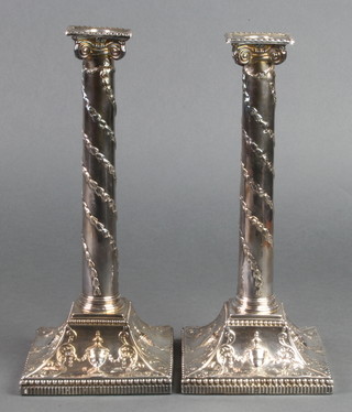 A pair of George III silver candlesticks with trancy columns on swept bases with urns and scrolls, Sheffield 1774, 11" 