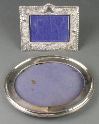 An oval silver photograph frame Birmingham 1926 9 1/2" x 8 1/2", a Victorian rectangular ditto with floral decoration Birmingham 1900 7" x 5 1/2" 